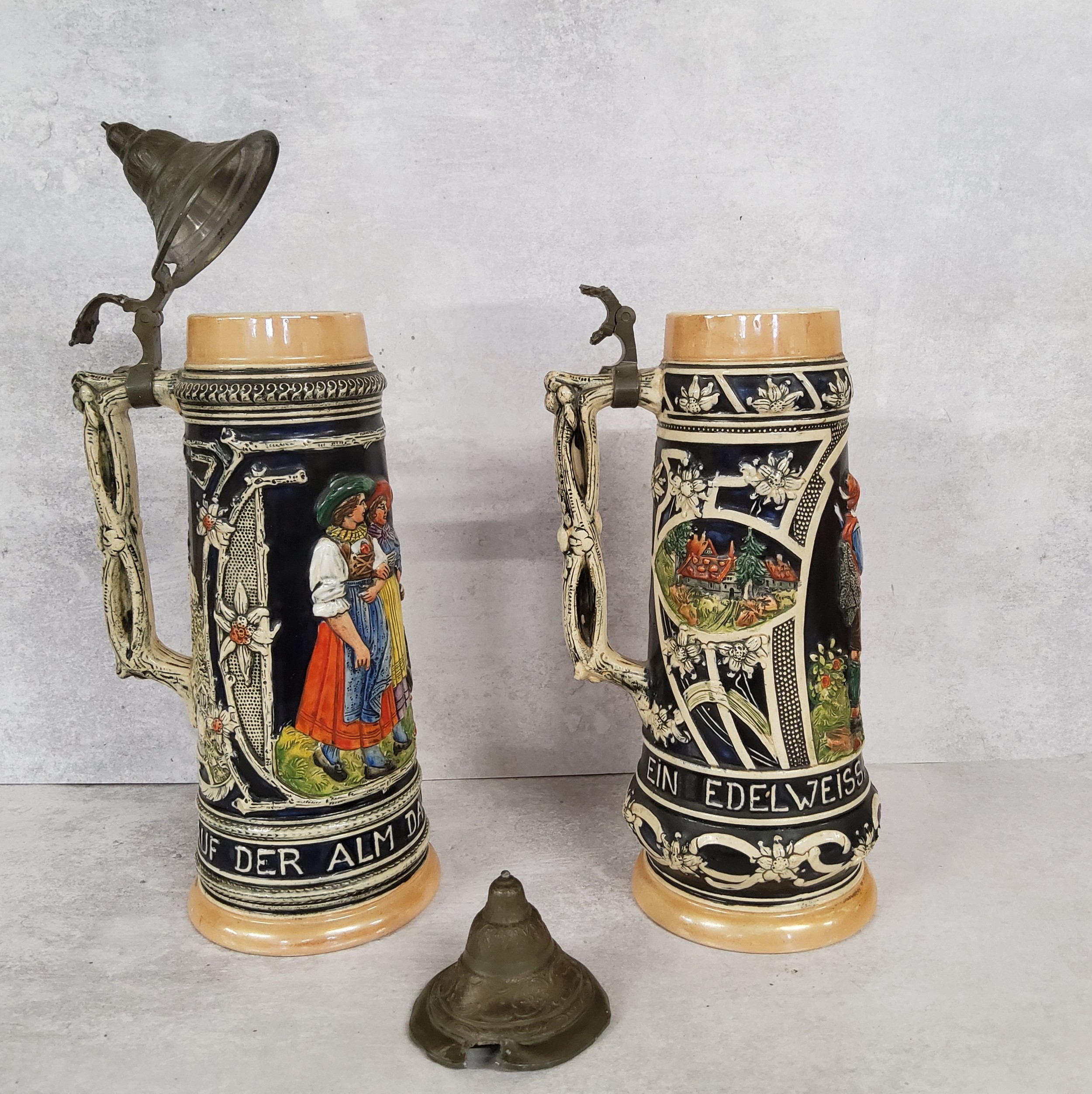 A pair of West Germany steins with covers, decorated in relief, 1.5 litres, marks to base, 36cm - Image 2 of 3