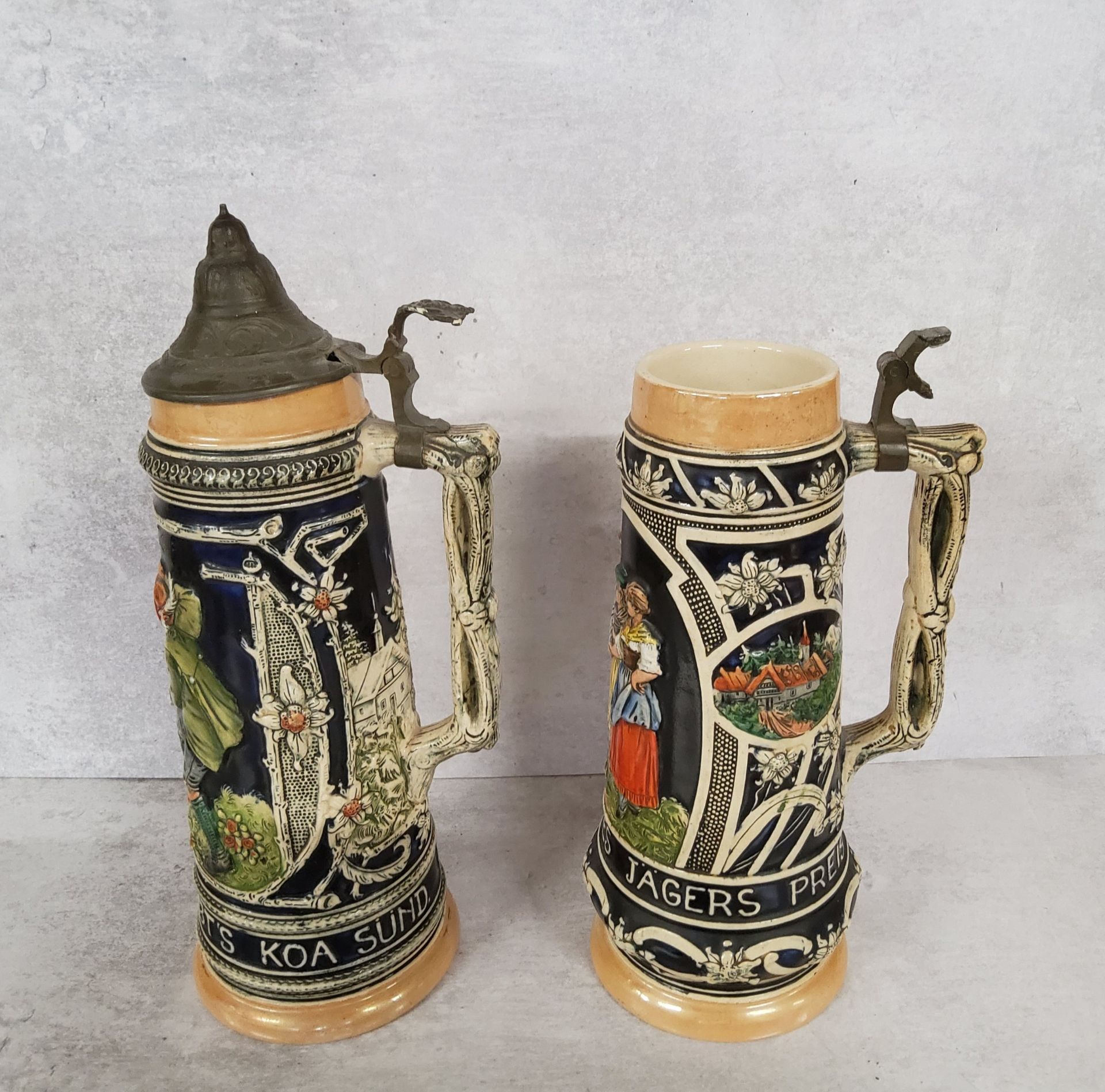 A pair of West Germany steins with covers, decorated in relief, 1.5 litres, marks to base, 36cm - Image 3 of 3