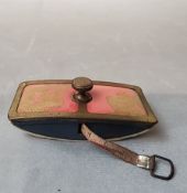 An early 20th Century metal novelty needlepoint tape measure in the form of a rocking ink blotter,