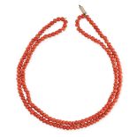 AN ANTIQUE TWO ROW CORAL BEAD NECKLACE requiring restringing, comprising two rows of polished