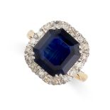 A SAPPHIRE AND DIAMOND CLUSTER RING in 18ct yellow gold, set with an octagonal step cut blue