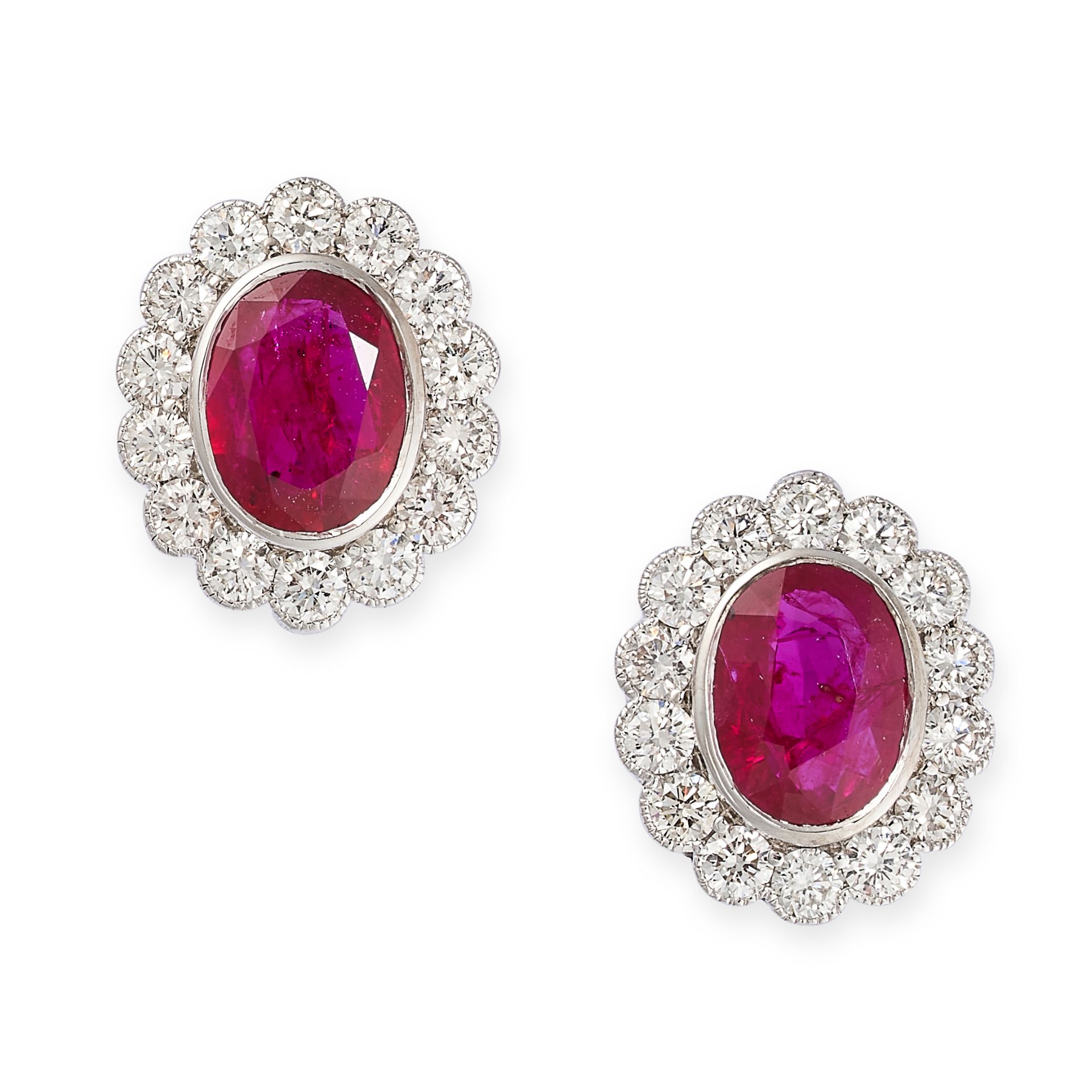 A PAIR OF RUBY AND DIAMOND CLUSTER EARRINGS in 18ct white gold, each set with an oval cut ruby, both