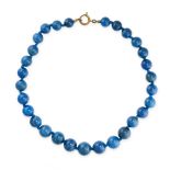 A BLUE HARDSTONE BEAD NECKLACE comprising a single row of twenty-nine graduate polished blue