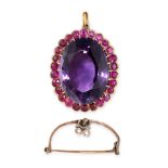 AN AMETHYST AND RUBY BROOCH / PENDANT set with an oval cut amethyst in a border of cushion cut