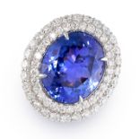 A FINE TANZANITE AND DIAMOND CLUSTER RING set with an oval cut tanzanite of 16.35 carats, in a