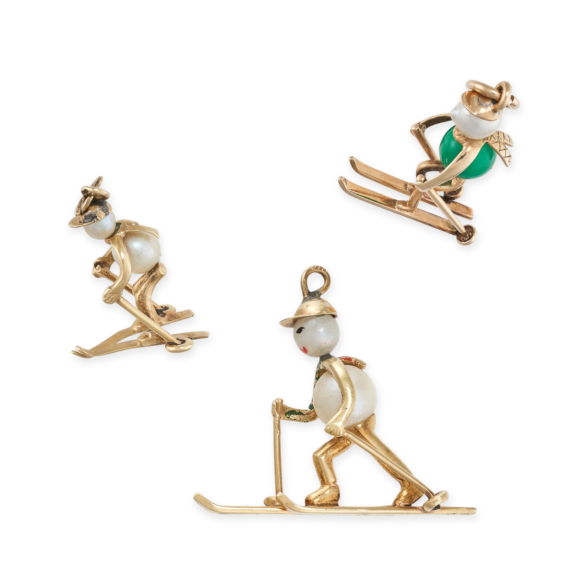 THREE PEARL AND GEMSET SKI CHARMS in yellow gold, each designed as a skier, set with pearls and