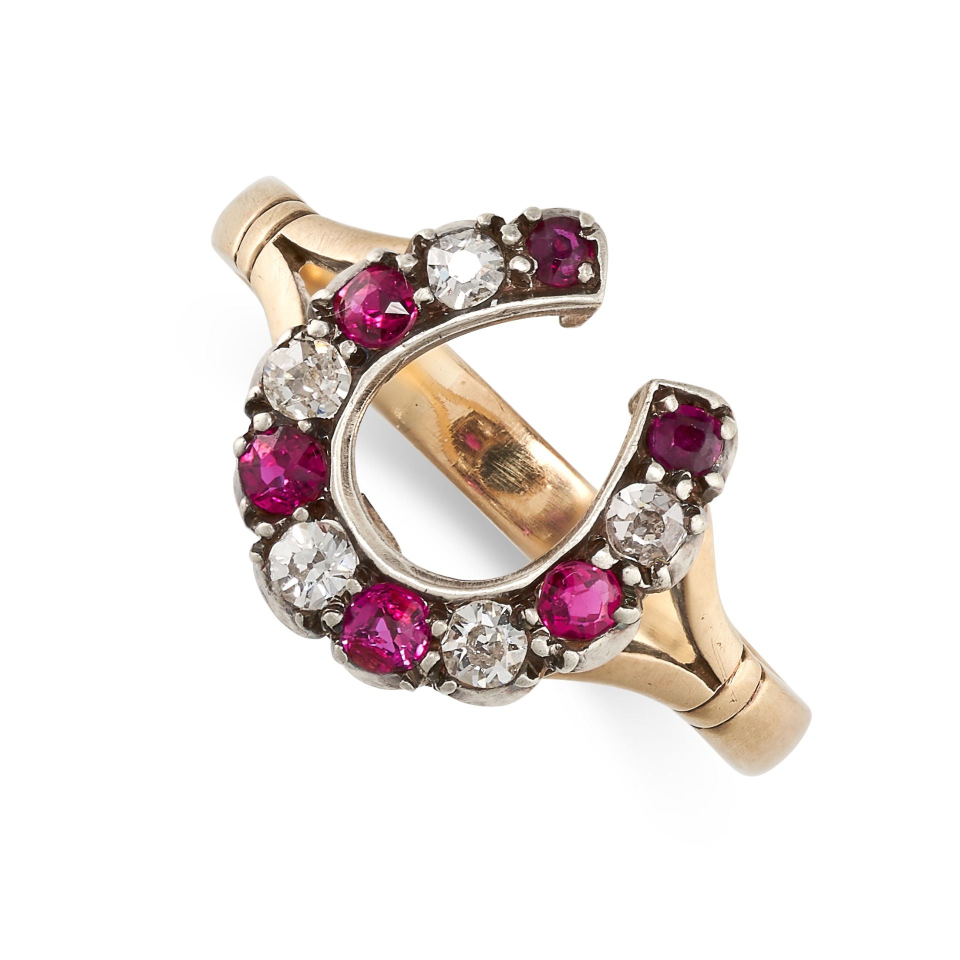 A RUBY AND DIAMOND HORSESHOE RING in yellow gold and silver, set with alternating round cut rubies