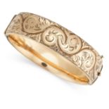 A VINTAGE ENGRAVED BANGLE the hinged body decorated with engraved scrolling foliate designs, stamped