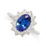 A TANZANITE AND DIAMOND CLUSTER RING in 18ct white gold, set with an oval cut tanzanite of 1.91