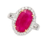 A RUBY AND DIAMOND RING in 18ct gold, set with an oval cut ruby of 3.78 carats within a cluster of