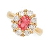 A SAPPHIRE AND DIAMOND DRESS RING in 18ct yellow gold, set with an oval cut orangey-pink sapphire of