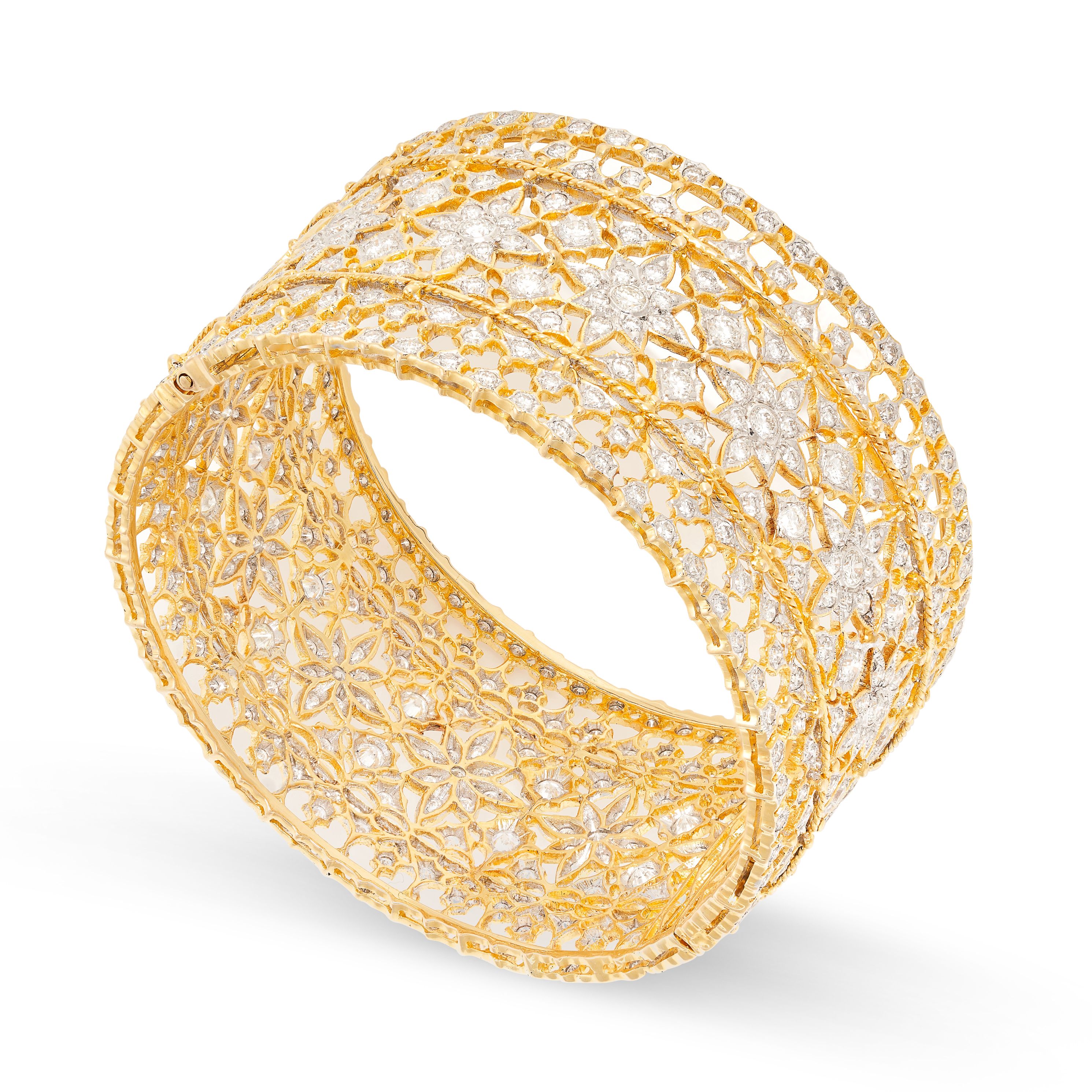 A DIAMOND BANGLE in yellow gold, in foliate design, set with round brilliant cut diamonds all