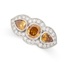 A BROWN DIAMOND DRESS RING in platinum, set with a round cut brown diamond between two pear cut