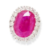 A RUBY AND DIAMOND CLUSTER RING in platinum, set with an oval cut ruby of 11.03 carats in a border