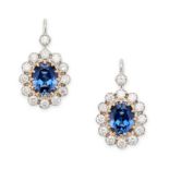 A PAIR OF SAPPHIRE AND DIAMOND CLUSTER EARRINGS each set with an oval cut sapphire in a border of