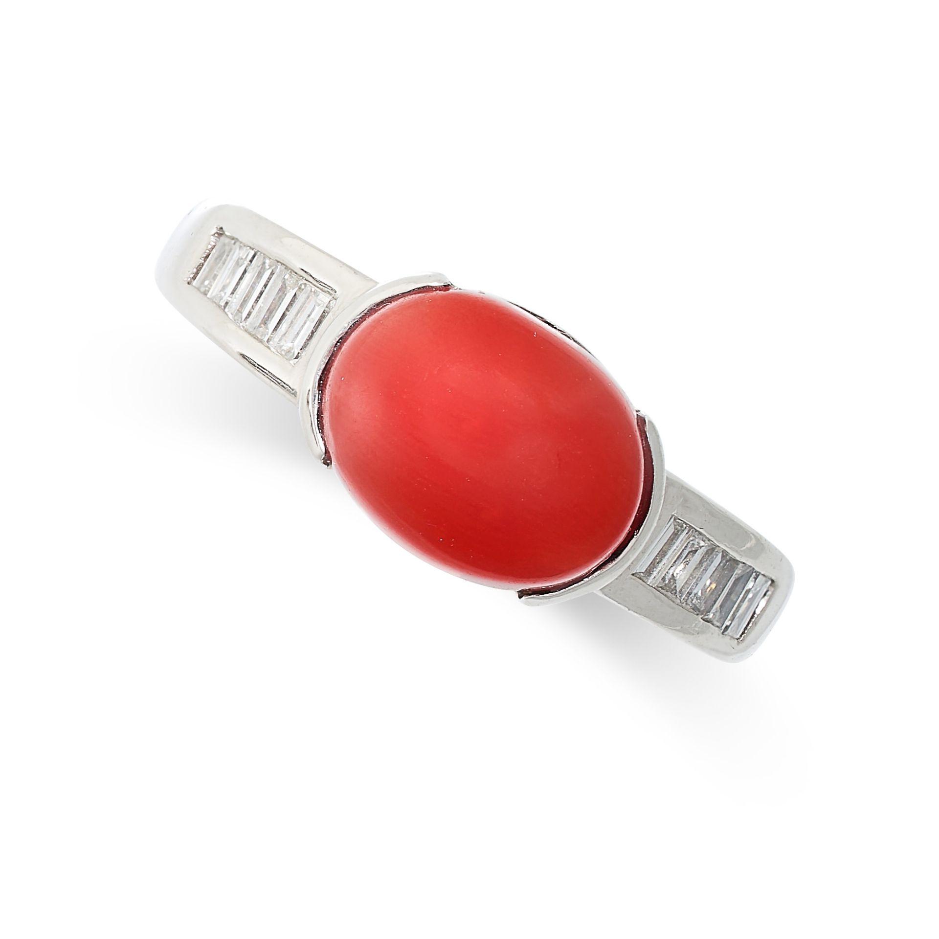 A CORAL AND DIAMOND RING in platinum, set with an oval cabochon coral accented by baguette cut