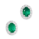 A PAIR OF EMERALD AND DIAMOND CLUSTER EARRINGS each set with an oval cut emerald in a border of