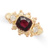A GARNET AND DIAMOND RING in 15ct yellow gold, set with a cushion cut garnet between two old cut