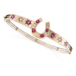 AN ANTIQUE RUBY AND DIAMOND HORSESHOE BANGLE in 9ct yellow gold, comprising a central horseshoe