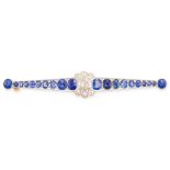 AN ART DECO SAPPHIRE AND DIAMOND BAR BROOCH in yellow gold and platinum, the tapering bar set with a