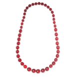 A CHERRY AMBER BEAD NECKLACE comprising a single row of polished cherry amber beads, 78.0cm, 106.7g.