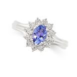 A TANZANITE AND DIAMOND CLUSTER RING set with an oval cut tanzanite in a cluster of illusion set