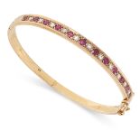 A VINTAGE RUBY AND DIAMOND BANGLE in 15ct yellow gold, set with a row of alternating round cut