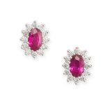 A PAIR OF RUBY AND DIAMOND CLUSTER EARRINGS in 18ct white gold, each set with an oval cut ruby in