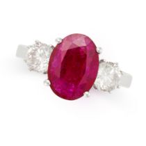 A RUBY AND DIAMOND THREE STONE RING in 18ct white gold, set with an oval cut ruby of 2.41 between