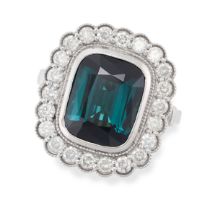A TEAL TOURMALINE AND DIAMOND CLUSTER RING set with a cushion cut teal-green tourmaline of 5.90