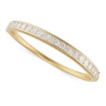 BOODLES, A DIAMOND BANGLE in 18ct yellow gold, set with a row of twenty princess cut diamonds all