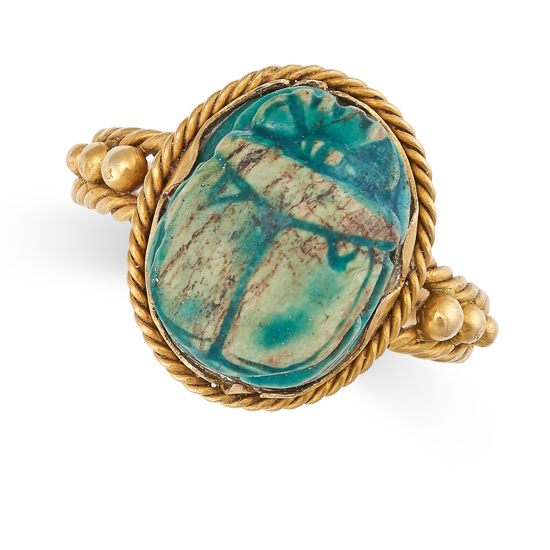 AN EGYPTIAN REVIVAL SCARAB BEETLE RING in yellow gold, the face set with a carved scarab, the band