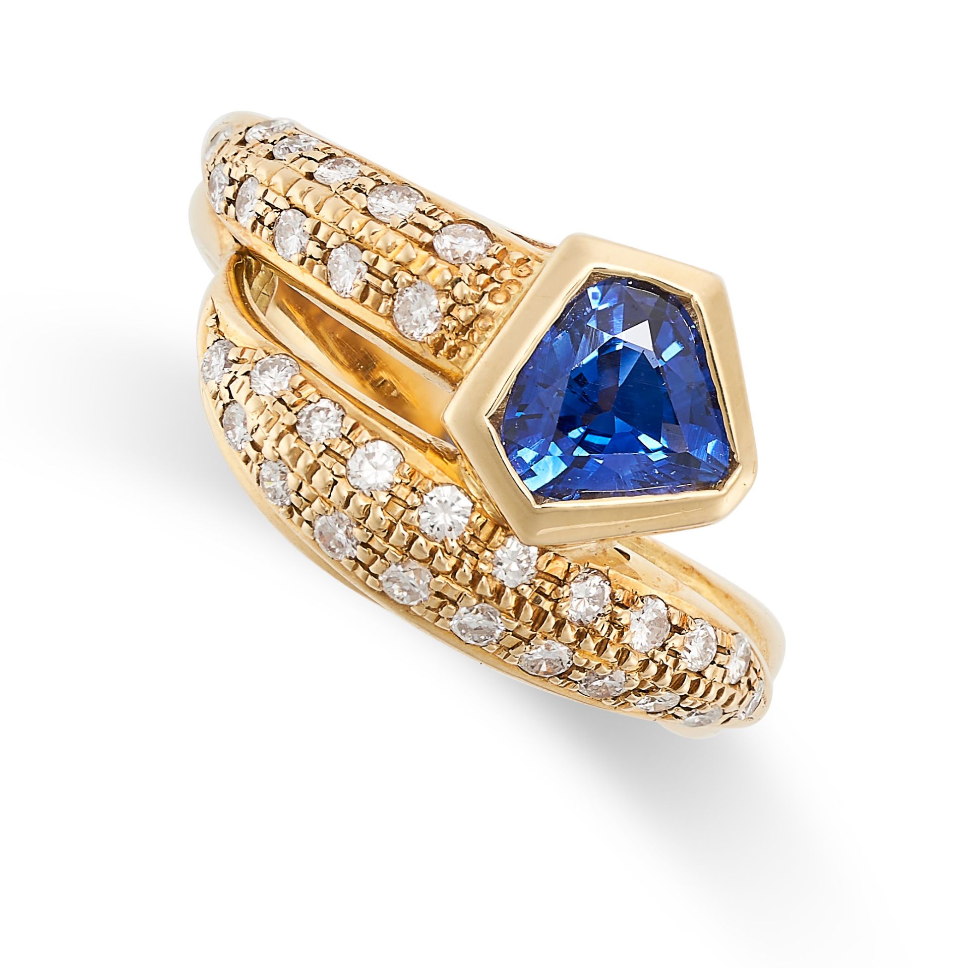A SAPPHIRE AND DIAMOND CROSSOVER RING in 18ct yellow gold, set with a shield shaped sapphire of 0.76