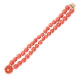 A CORAL BRACELET comprising two rows of faceted coral beads, the clasp set with a cluster of