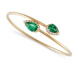 AN EMERALD AND DIAMOND BANGLE in yellow gold, in cross over design, each end set with a pear cut