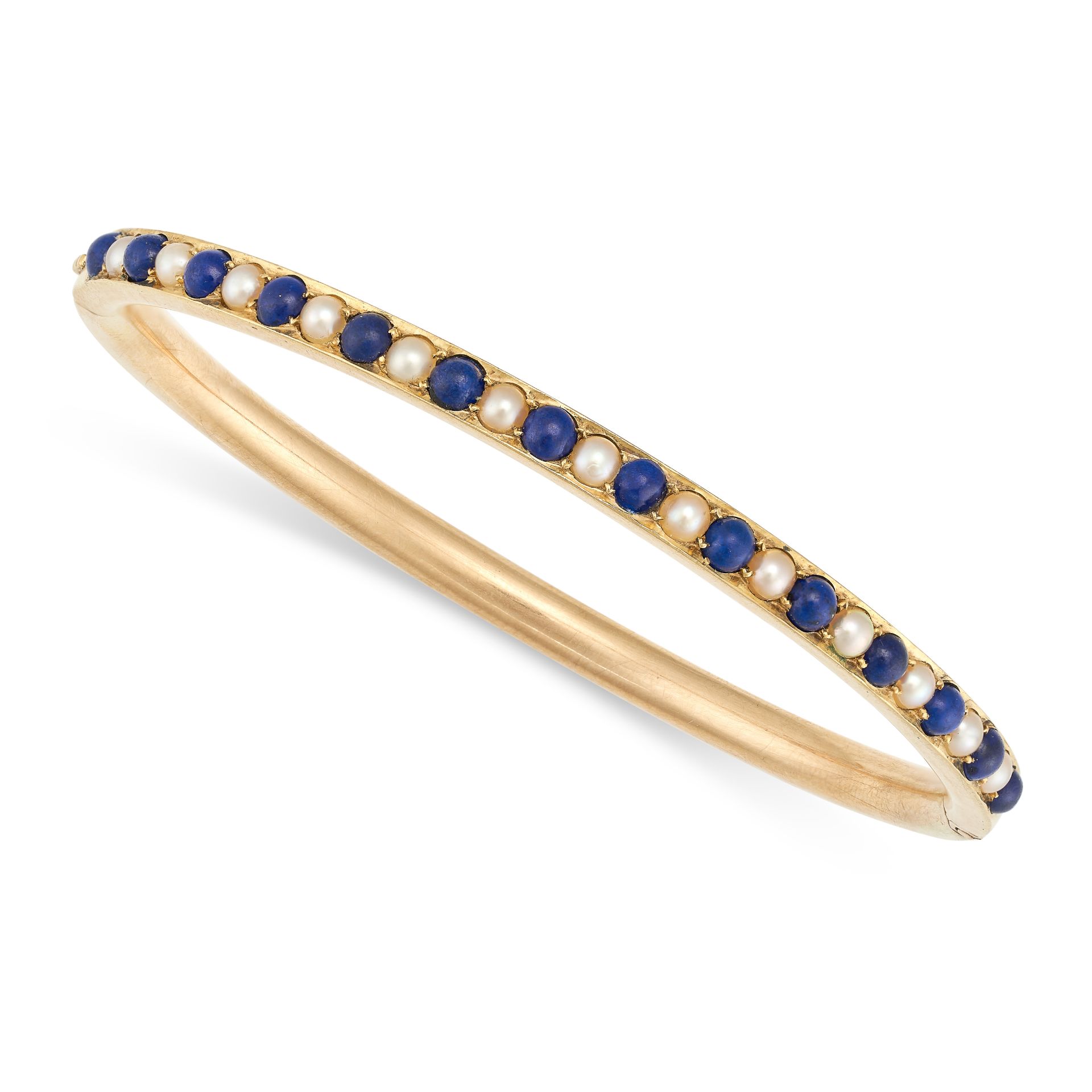 AN ANTIQUE LAPIS LAZULI AND PEARL BANGLE in yellow gold, the hinged bangle set with a row of alte...