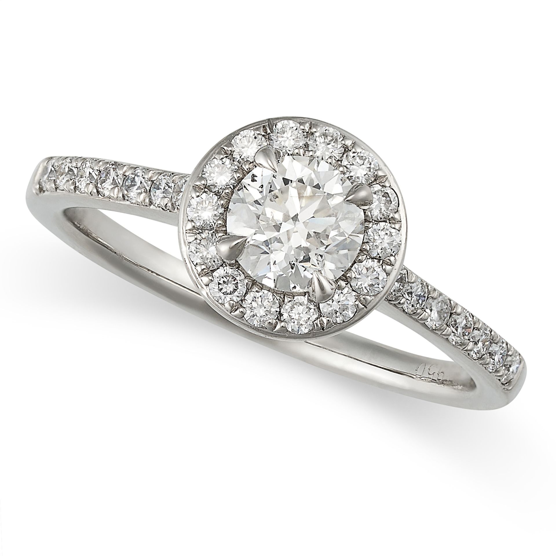 A DIAMOND CLUSTER RING in platinum, set with a round brilliant cut diamond in a border of round c...