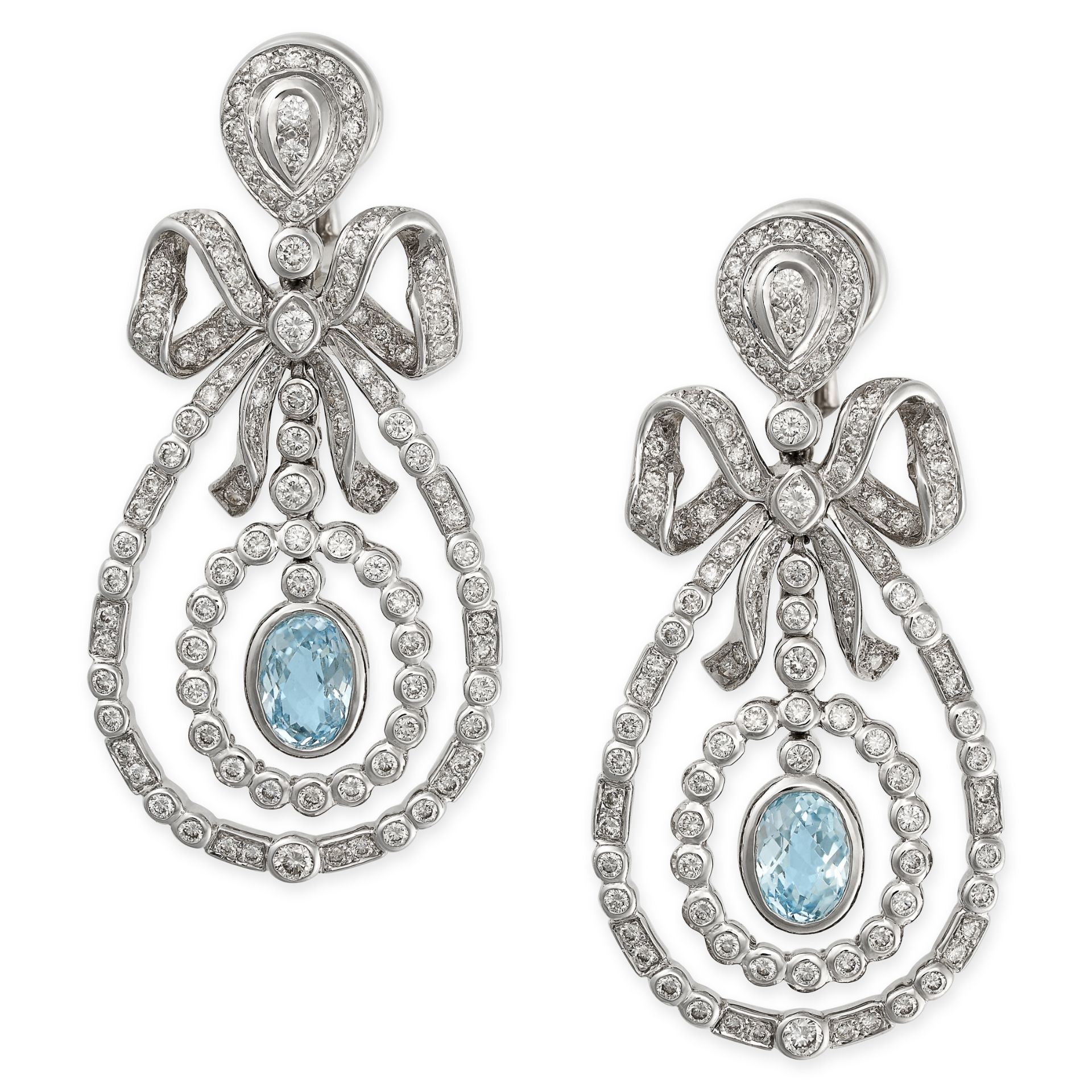 A PAIR OF BLUE TOPAZ AND DIAMOND PENDANT EARRINGS in white gold, each designed as a ribbon tied into