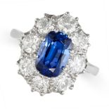 A SAPPHIRE AND DIAMOND CLUSTER RING in platinum, set with a cushion cut sapphire of approximately...