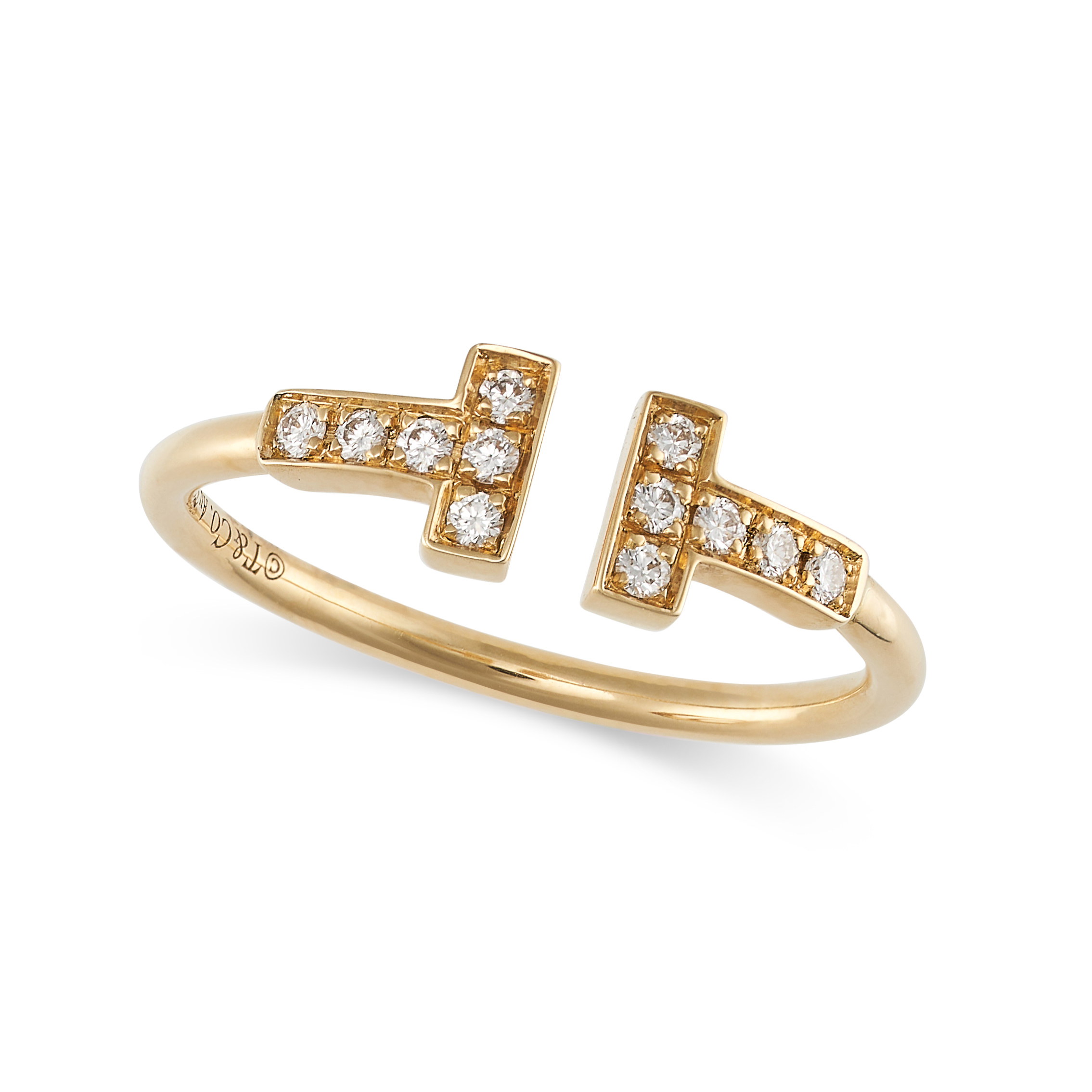 TIFFANY & CO., A DIAMOND T WIRE RING in 18ct yellow gold, designed as two T motifs set with round...