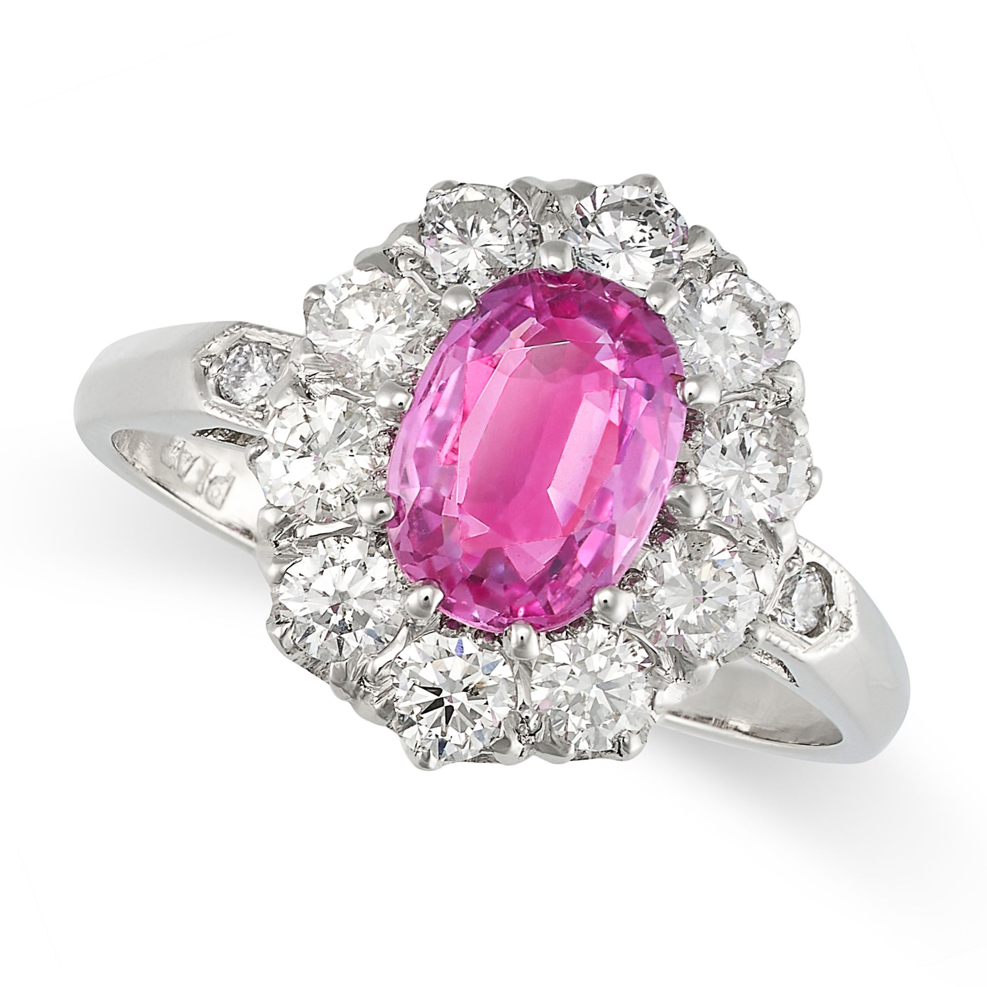 A PINK SAPPHIRE AND DIAMOND CLUSTER RING in platinum, set with an oval cut pink sapphire of appro...