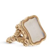 AN ANTIQUE CHALCEDONY FOB PENDANT in yellow gold, in scrolling form set with a polished carnelian...