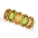 A VINTAGE CITRINE AND PERIDOT RING in yellow gold, set with alternating oval cut citrine and peri...