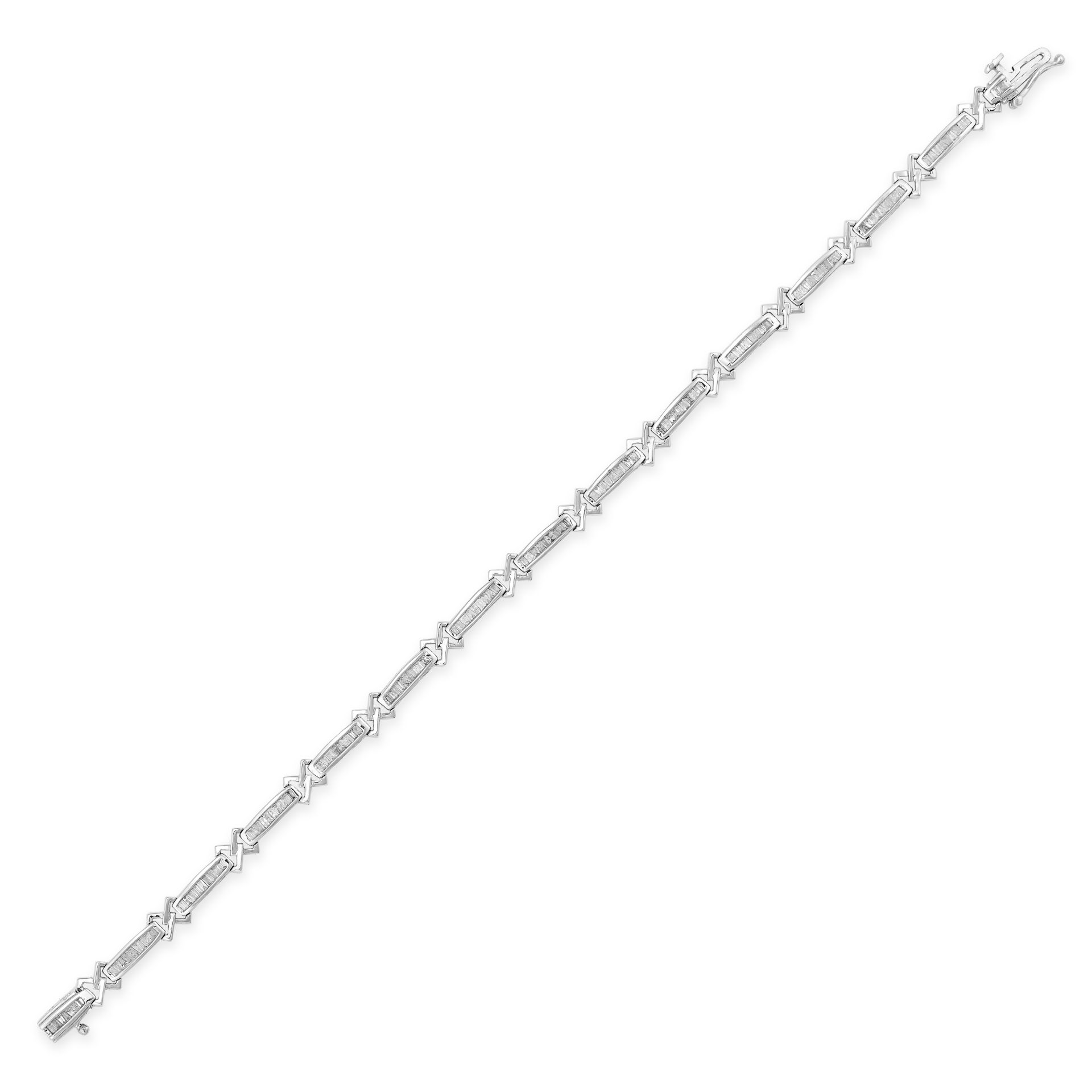 A DIAMOND BRACELET in white gold, comprising a row of links set with tapered baguette diamonds in...