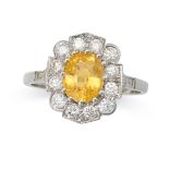A YELLOW SAPPHIRE AND DIAMOND CLUSTER RING in platinum, set with an oval cut yellow sapphire of a...