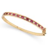 NO RESERVE - A RUBY AND DIAMOND BANGLE in 9ct yellow gold, the hinged body set with a row of alte...