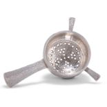 AN ARTS AND CRAFTS SILVER TEA STRAINER