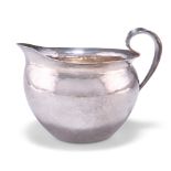 AN ARTS AND CRAFTS SPOT-HAMMERED SILVER JUG