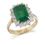 AN 18 CARAT GOLD EMERALD AND DIAMOND CLUSTER RING