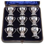 A SET OF NINE EDWARDIAN SILVER CUPS